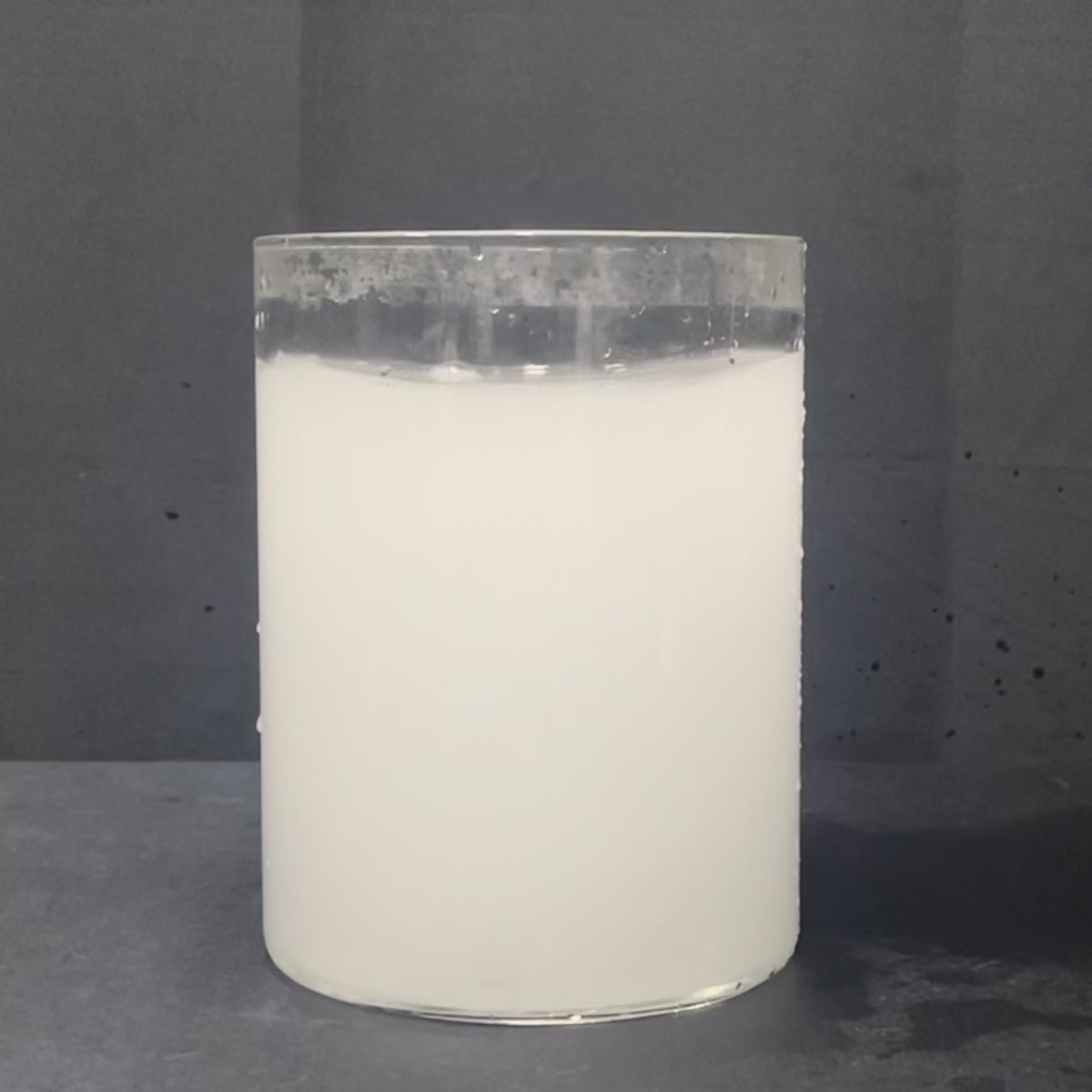 Water from a ZHONGHE bubble generator caught in a clear glass; the water looks milky white